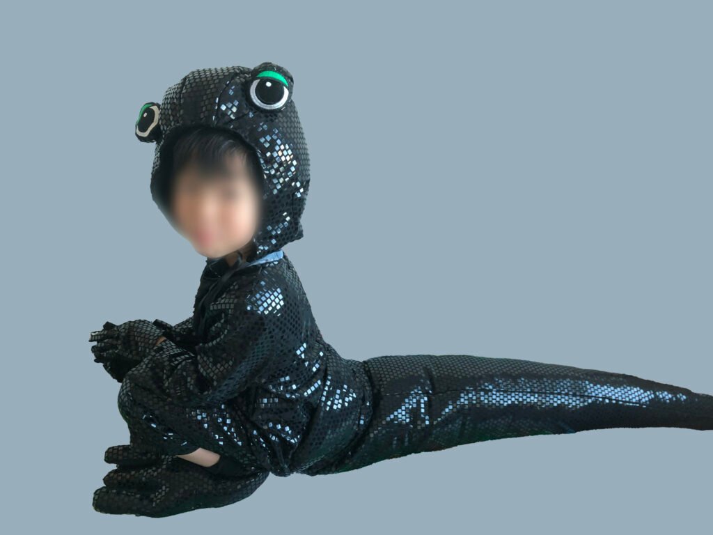 Handmade salamander costume head with green-rimmed eyes and a long tail