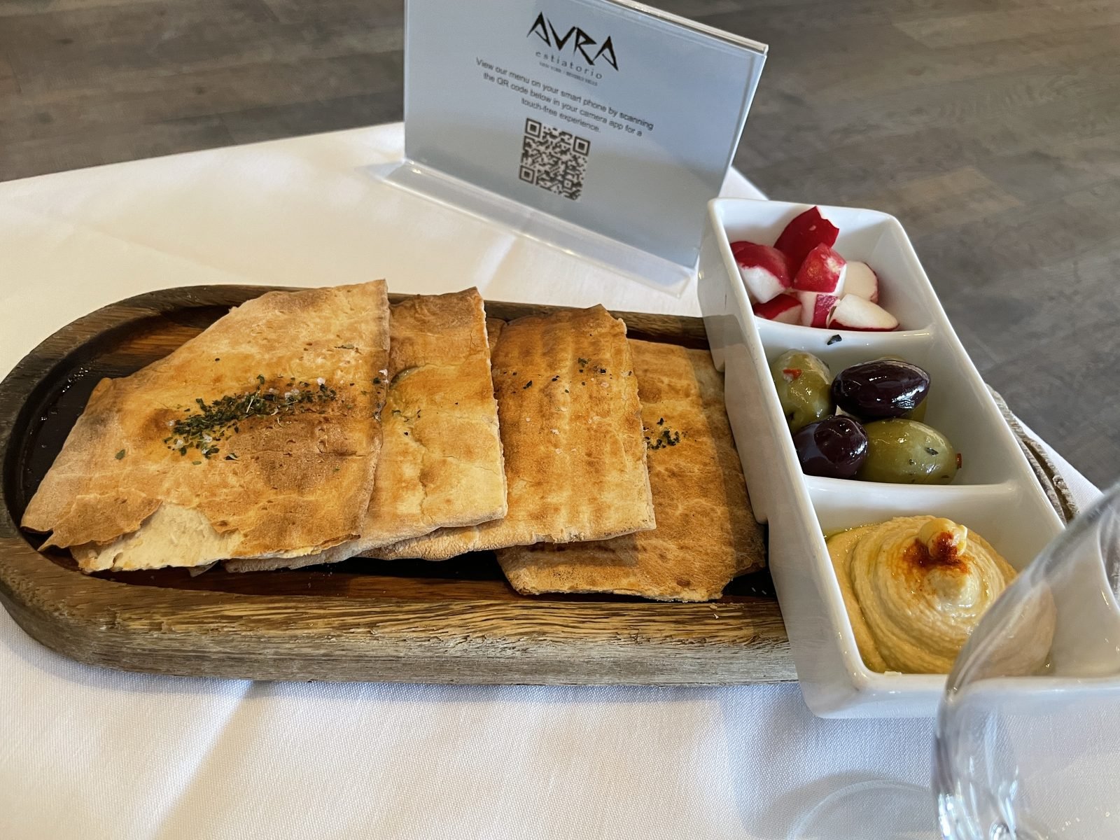 Warm pita bread on a wooden board at Avra Beverly Hills