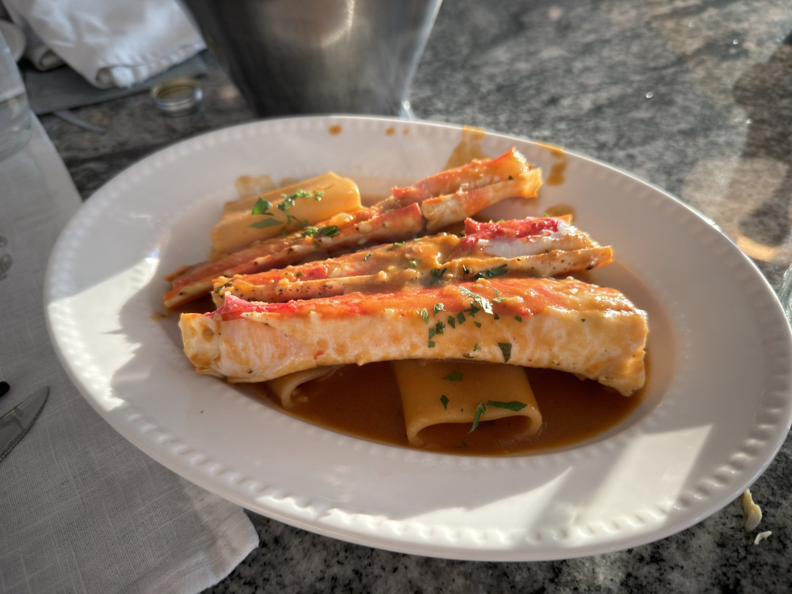 King crab legs laid over wide pasta in an orange bisque at Crab 52 Seoul
