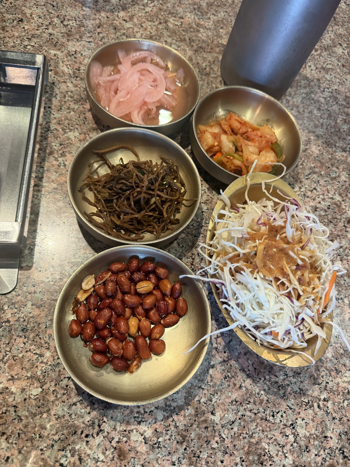 Small dishes of peanuts, bean sprouts and seasoned greens at Fei Xiang Gong in Los Angeles Koreatown