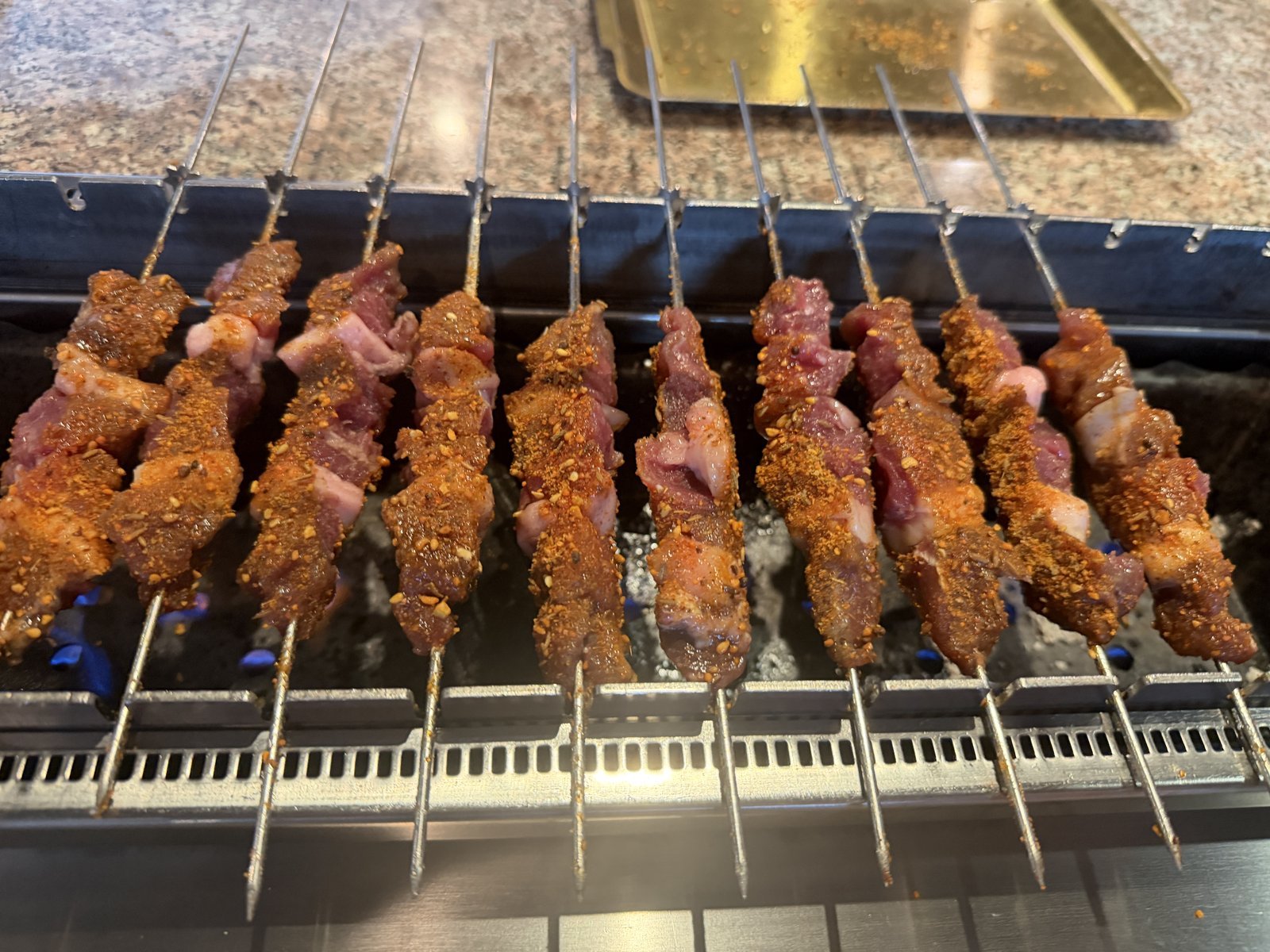 Lamb skewers cooking over the built-in rotating grill at Fei Xiang Gong in Los Angeles Koreatown