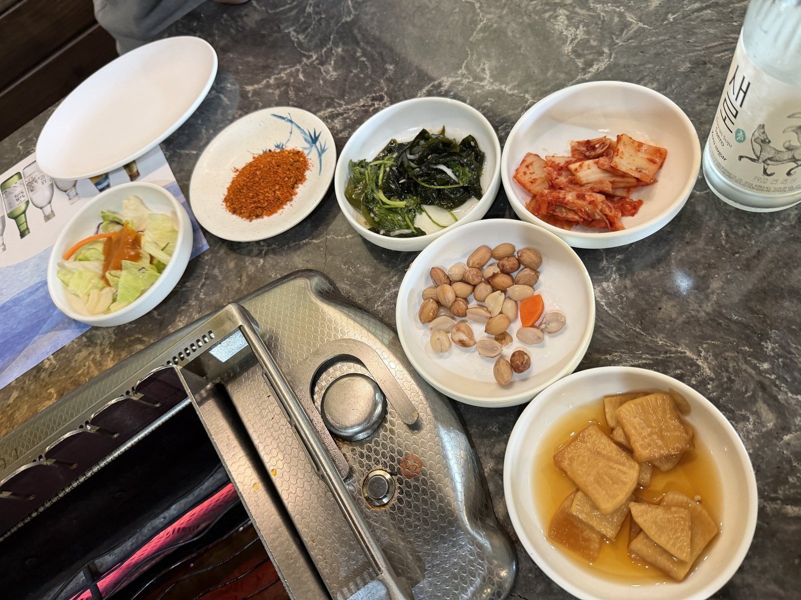 Banchan dishes and the built-in grill at a table at Feng Mao in Los Angeles Koreatown
