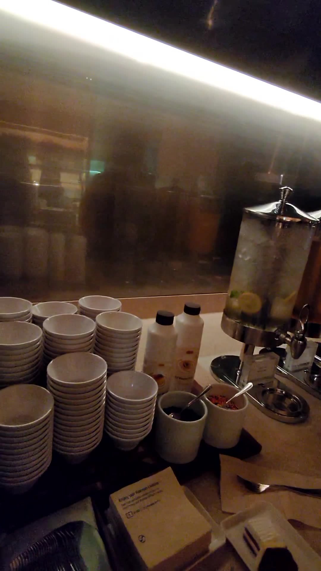Self-serve drinks station with stacked cups and dispensers at the Korean Air lounge