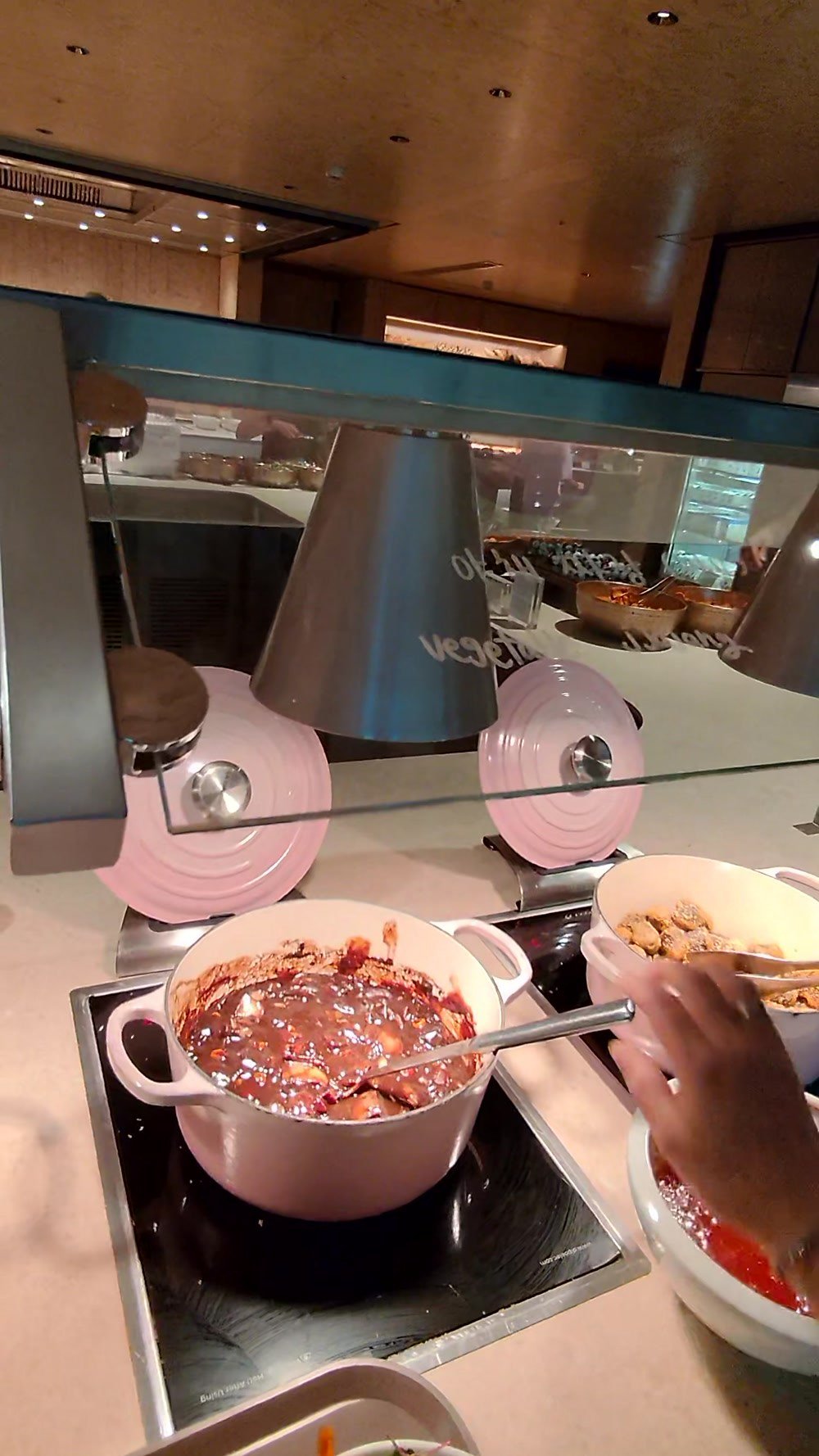 A braised dish in an enamel pot on an induction warmer at the Korean Air lounge buffet