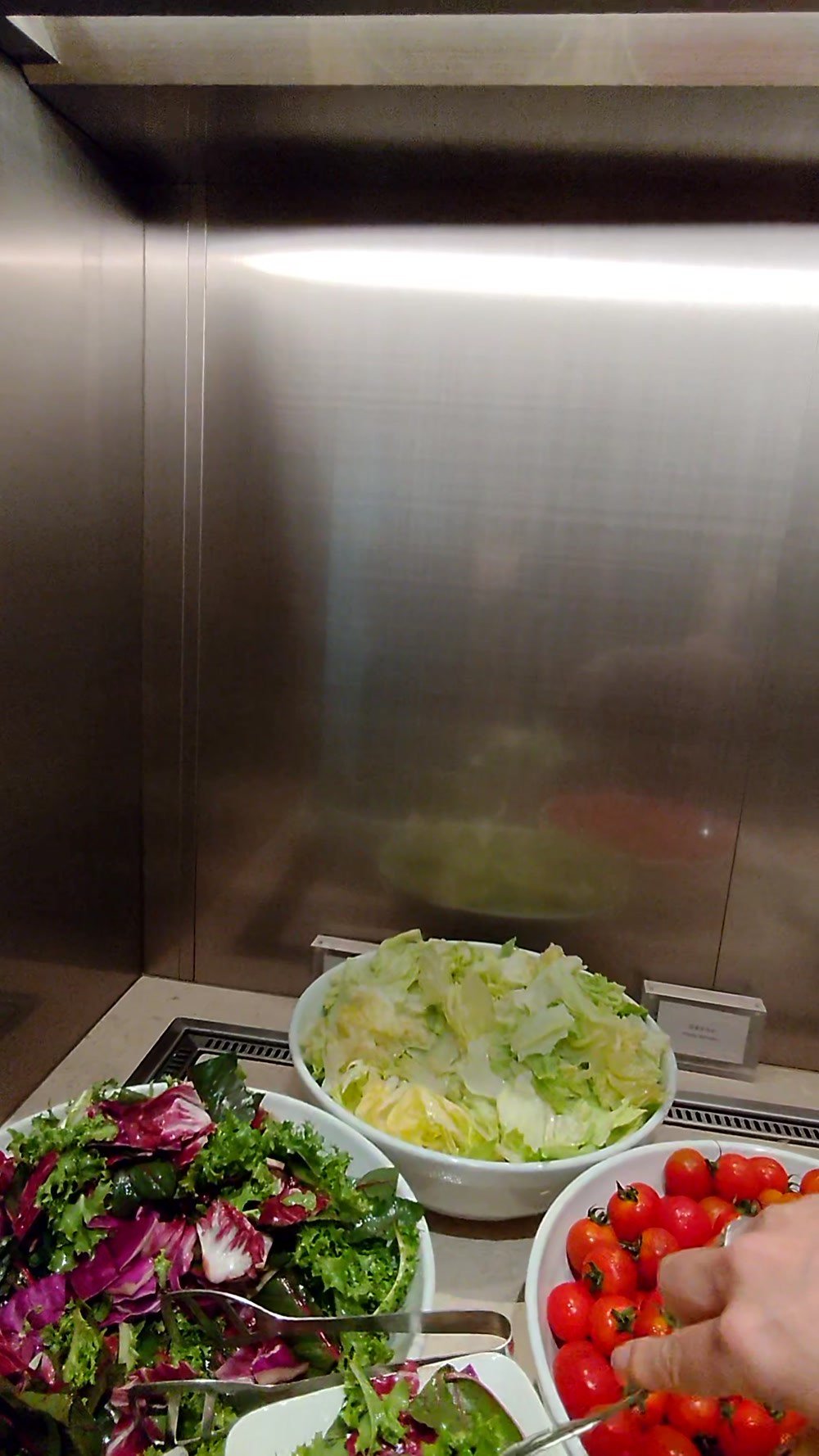 Salad bar with mixed greens, iceberg lettuce and cherry tomatoes at the Korean Air lounge in Incheon