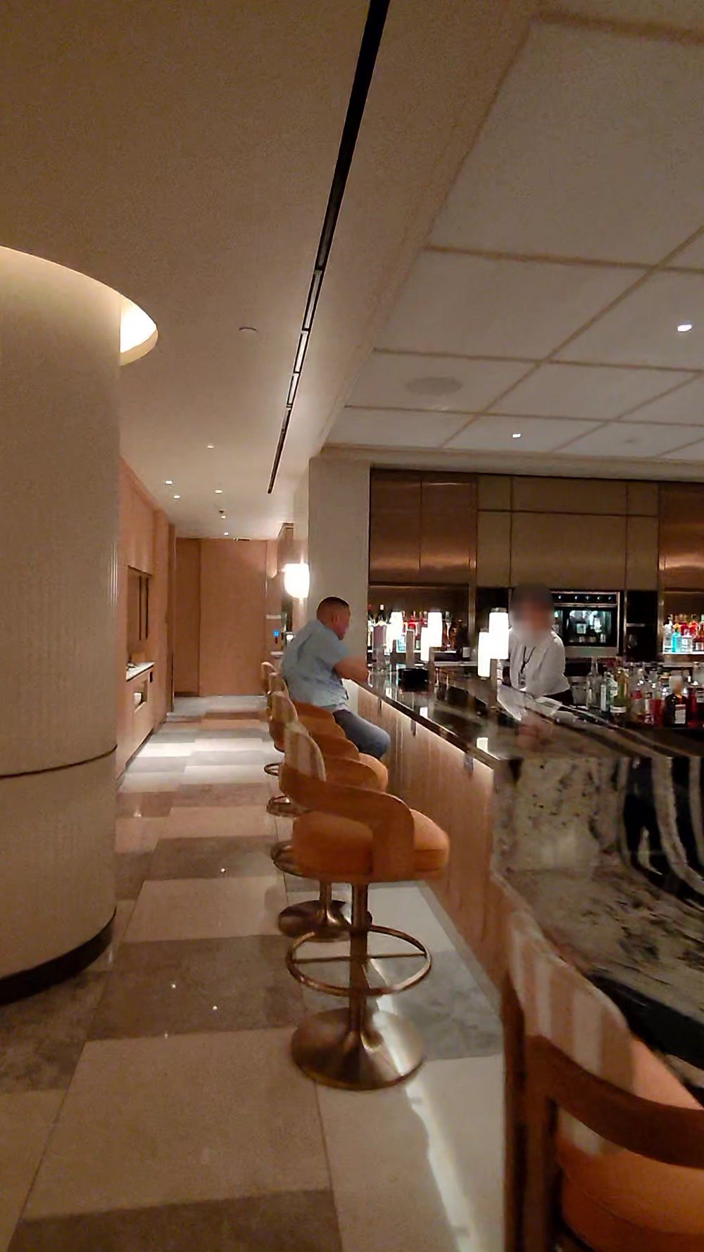 The stone bar counter with stools inside the Korean Air lounge at LAX