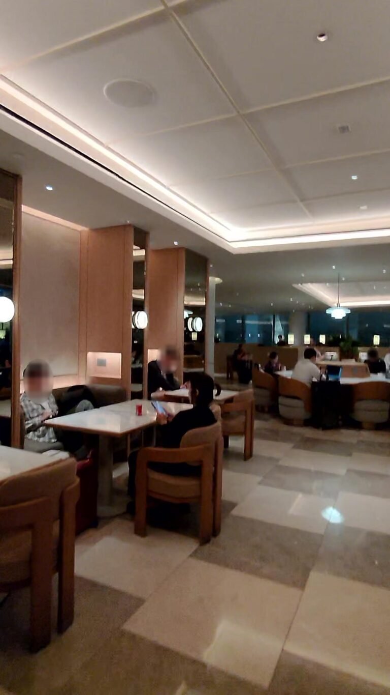 Dining area with marble floors, low tables and armchairs in the Korean Air lounge at LAX