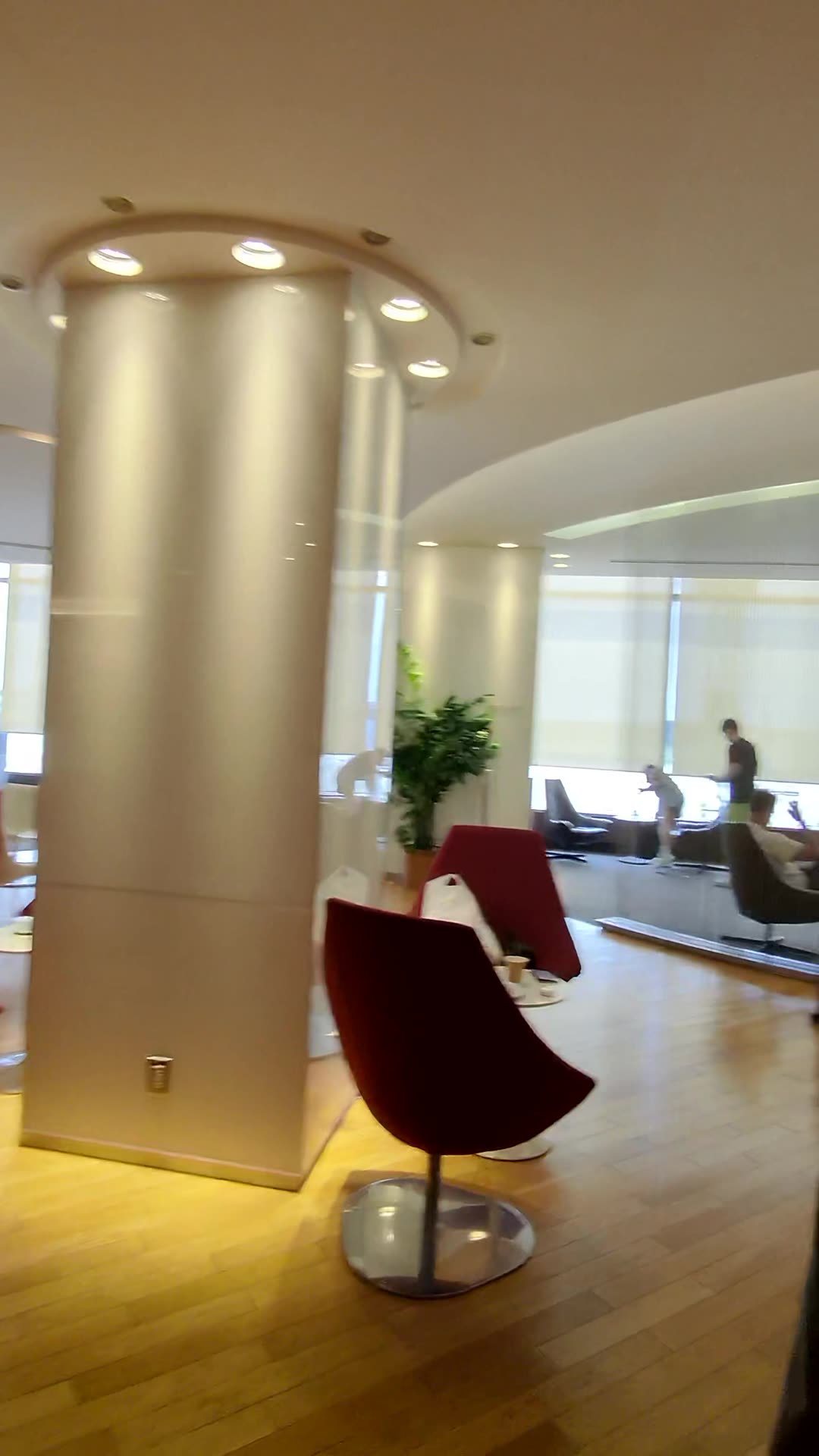 A lit column and burgundy chairs in the Korean Air lounge at Narita Terminal 1