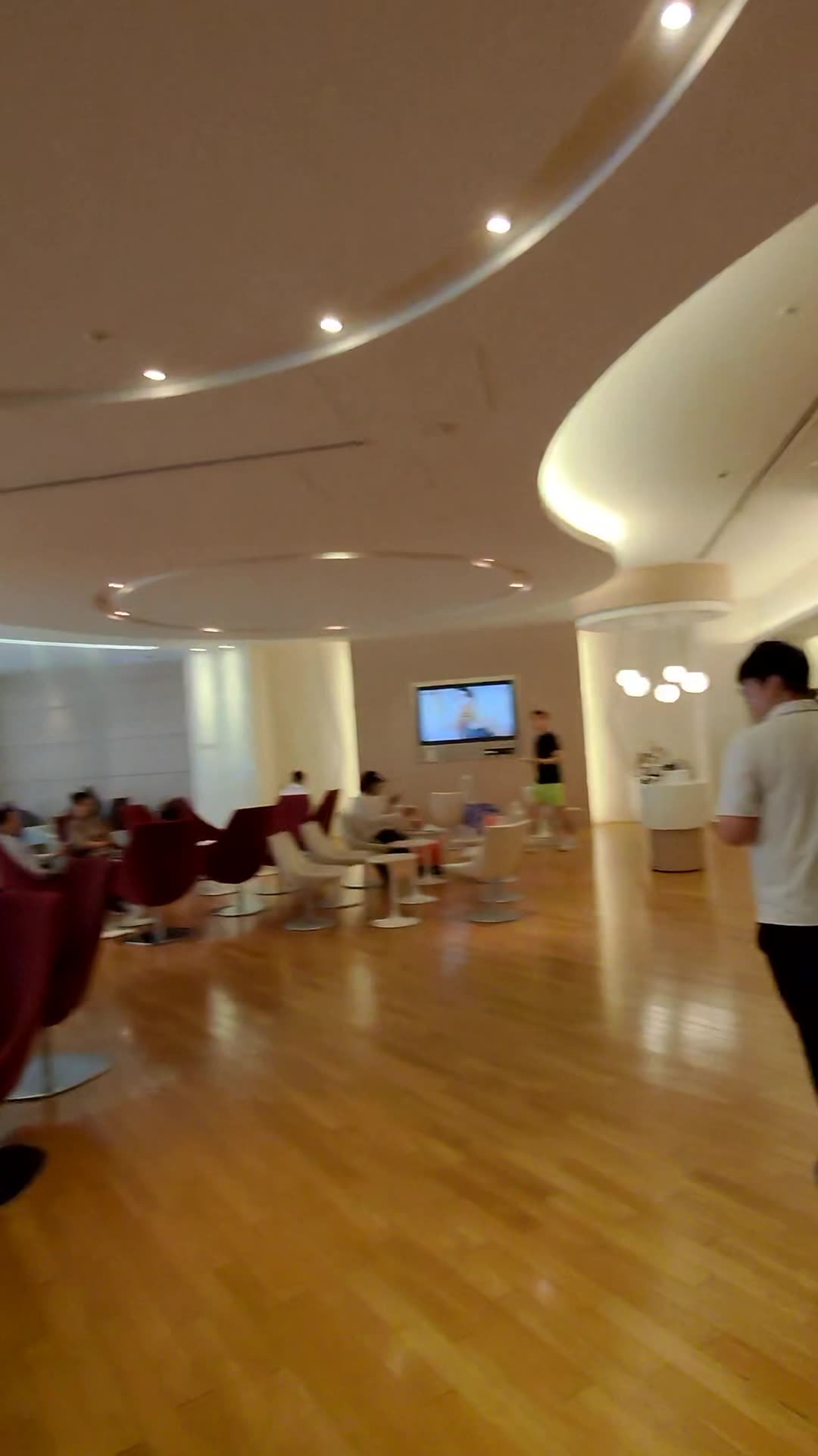 Burgundy armchairs and low tables in the seating area of the Korean Air lounge at Narita