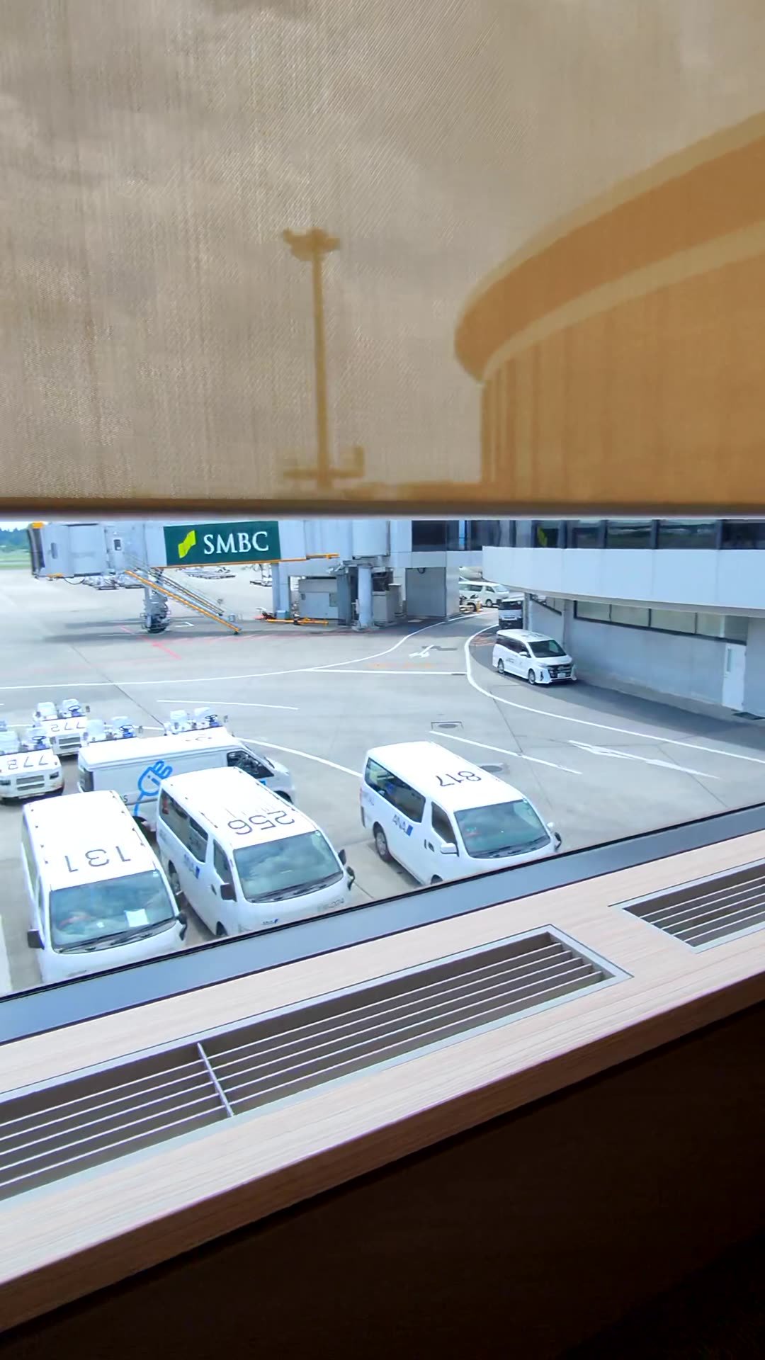 Window view of the airport apron and service vehicles from the Korean Air lounge at Narita