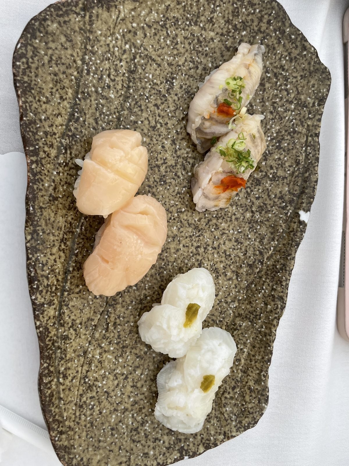 A selection of nigiri arranged on a stone plate at Matsumoto sushi