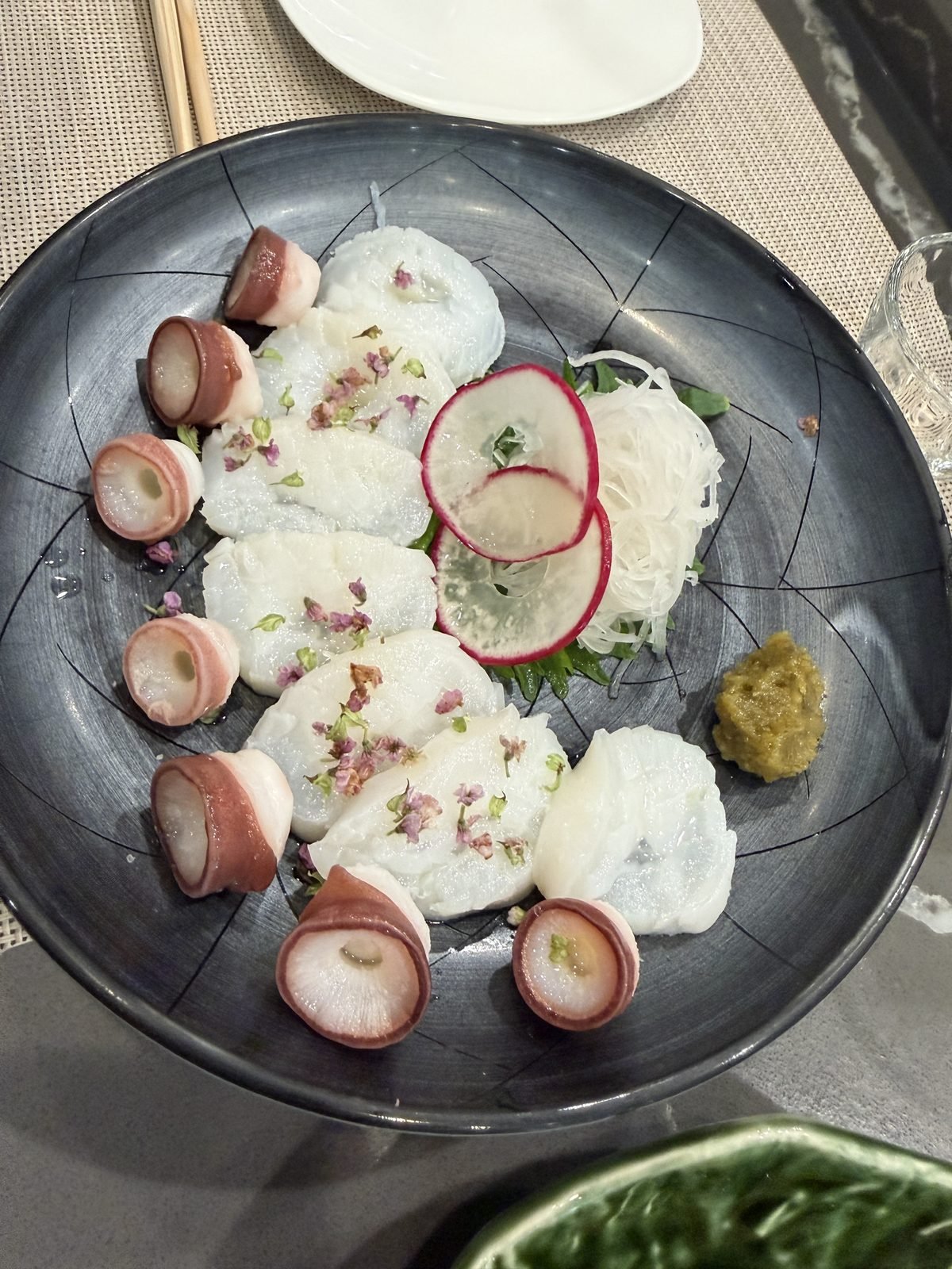 Thinly sliced octopus sashimi with radish and edible flowers at Matsumoto sushi
