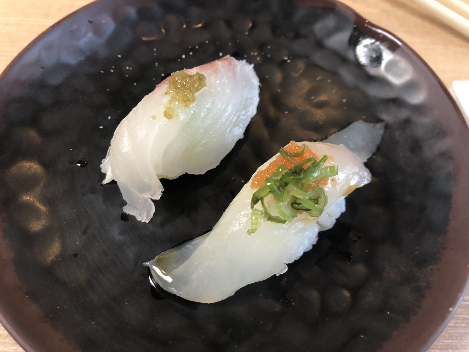 Beverly Hills Sasabune two white fish nigiri on a dark plate