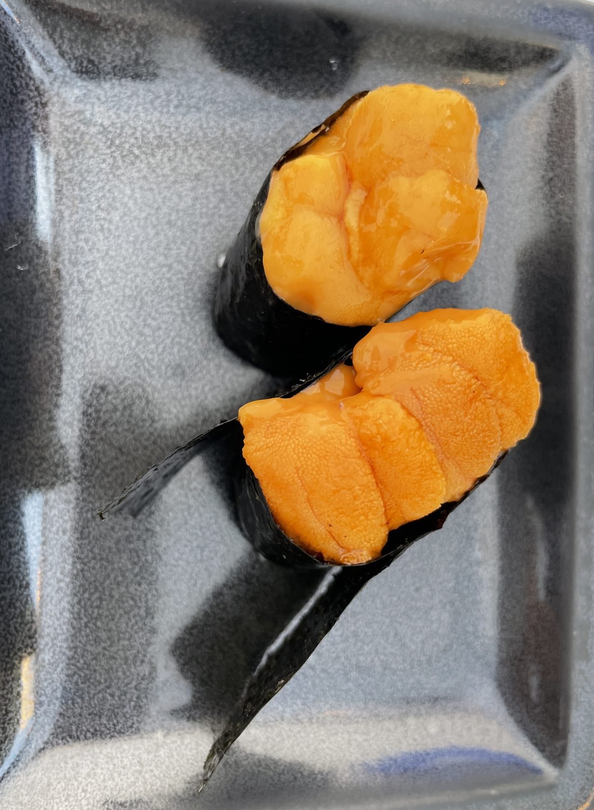 Sea urchin nigiri on a dark rectangular plate at Matsumoto sushi