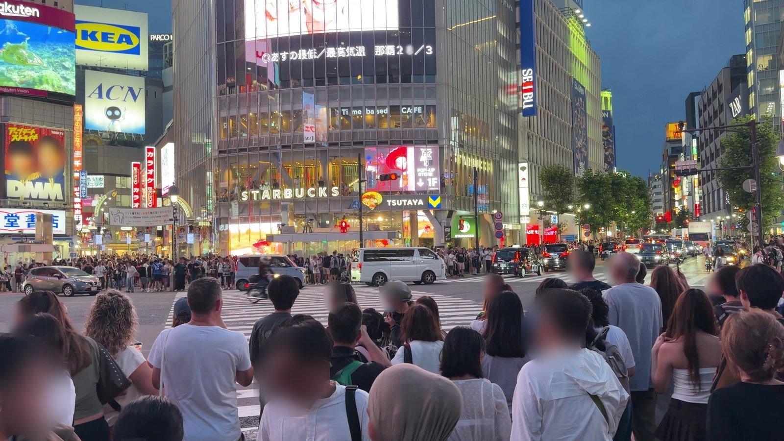 Neon signs and video screens around Shibuya Crossing at night
