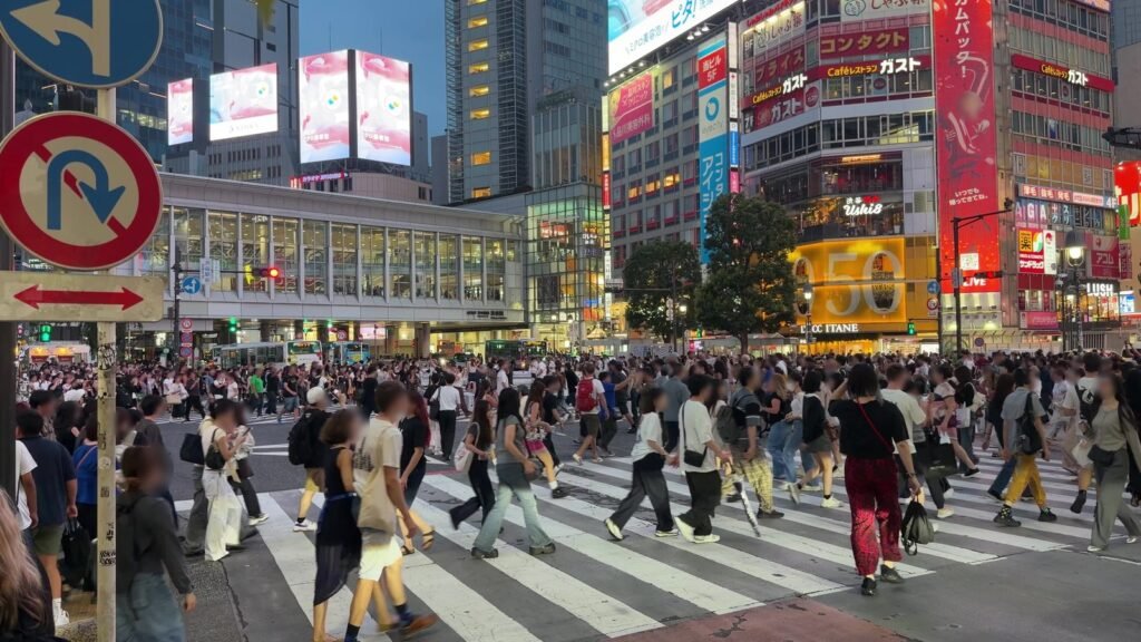 Crowds filling Shibuya Crossing in Tokyo at dusk