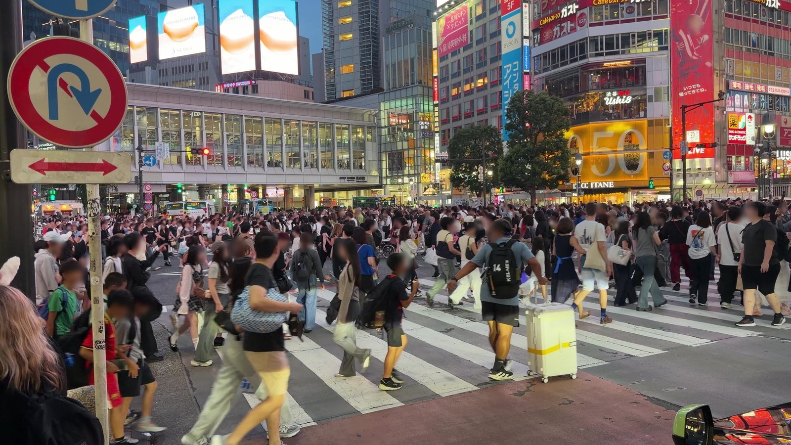 People walking in every direction across the Shibuya scramble crossing