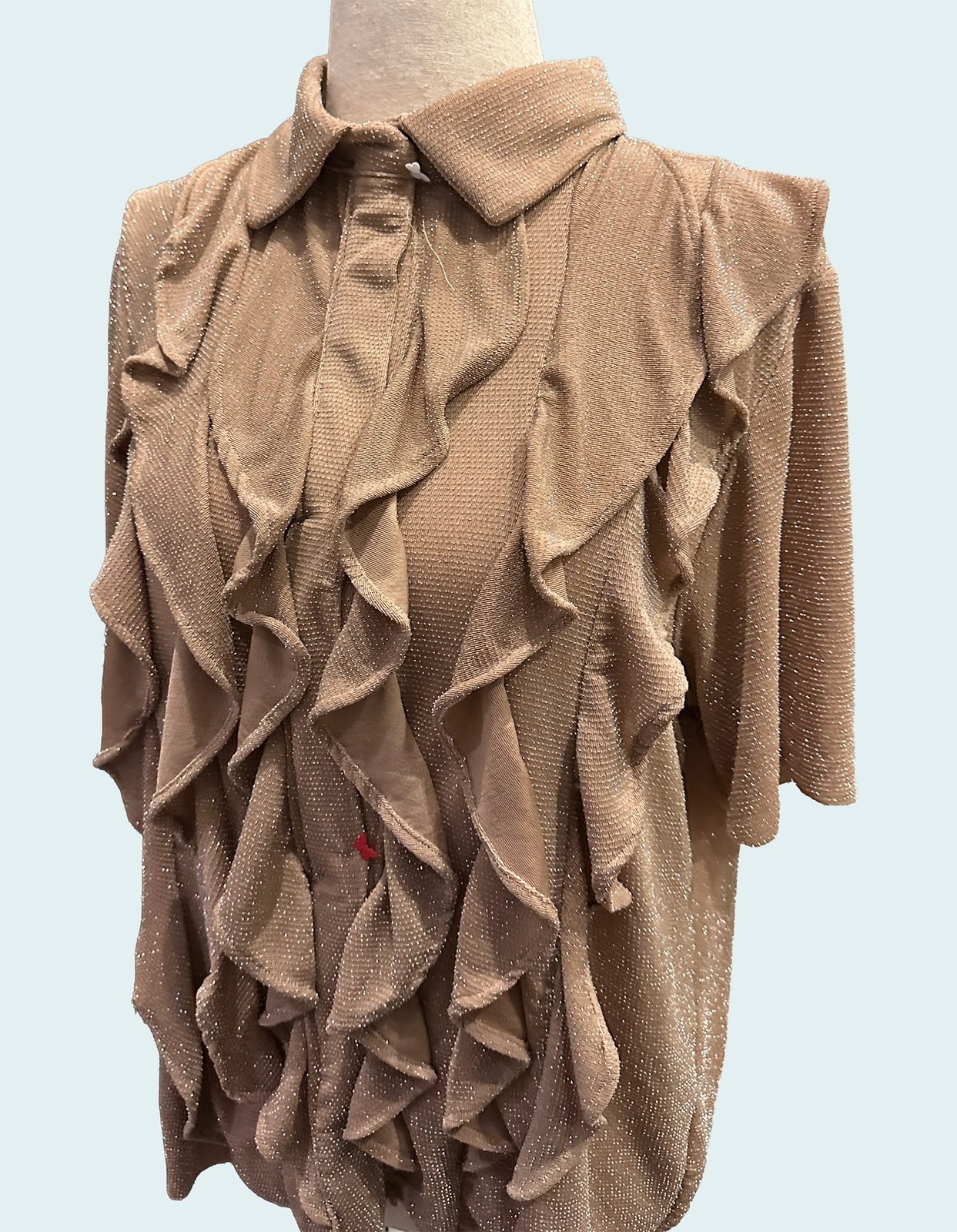 Handmade beige ruffle blouse on a dress form