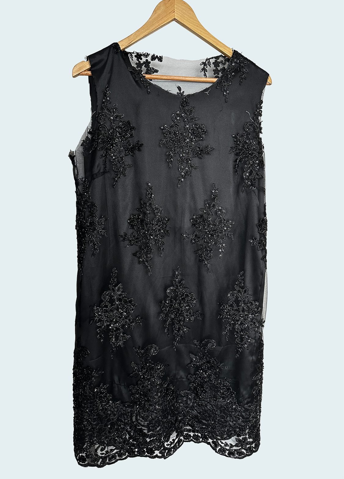 Handmade black beaded lace shift dress on a hanger