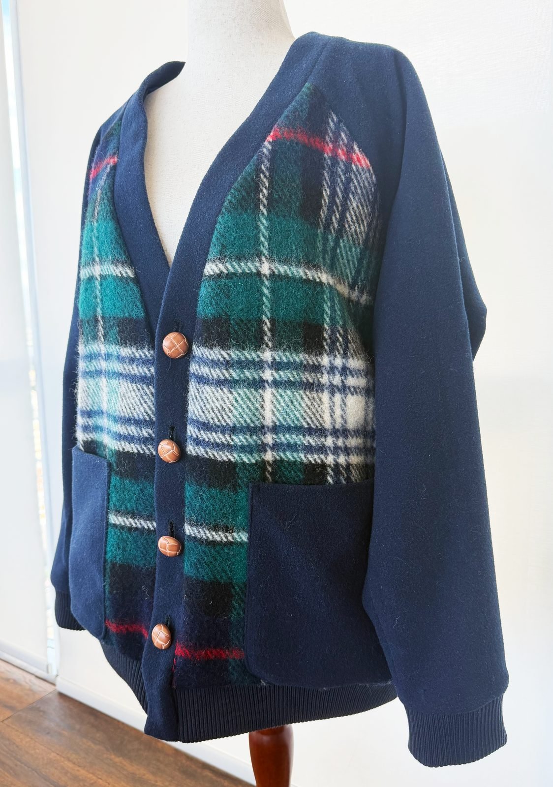 Handmade navy wool cardigan with a green plaid front panel and patch pockets