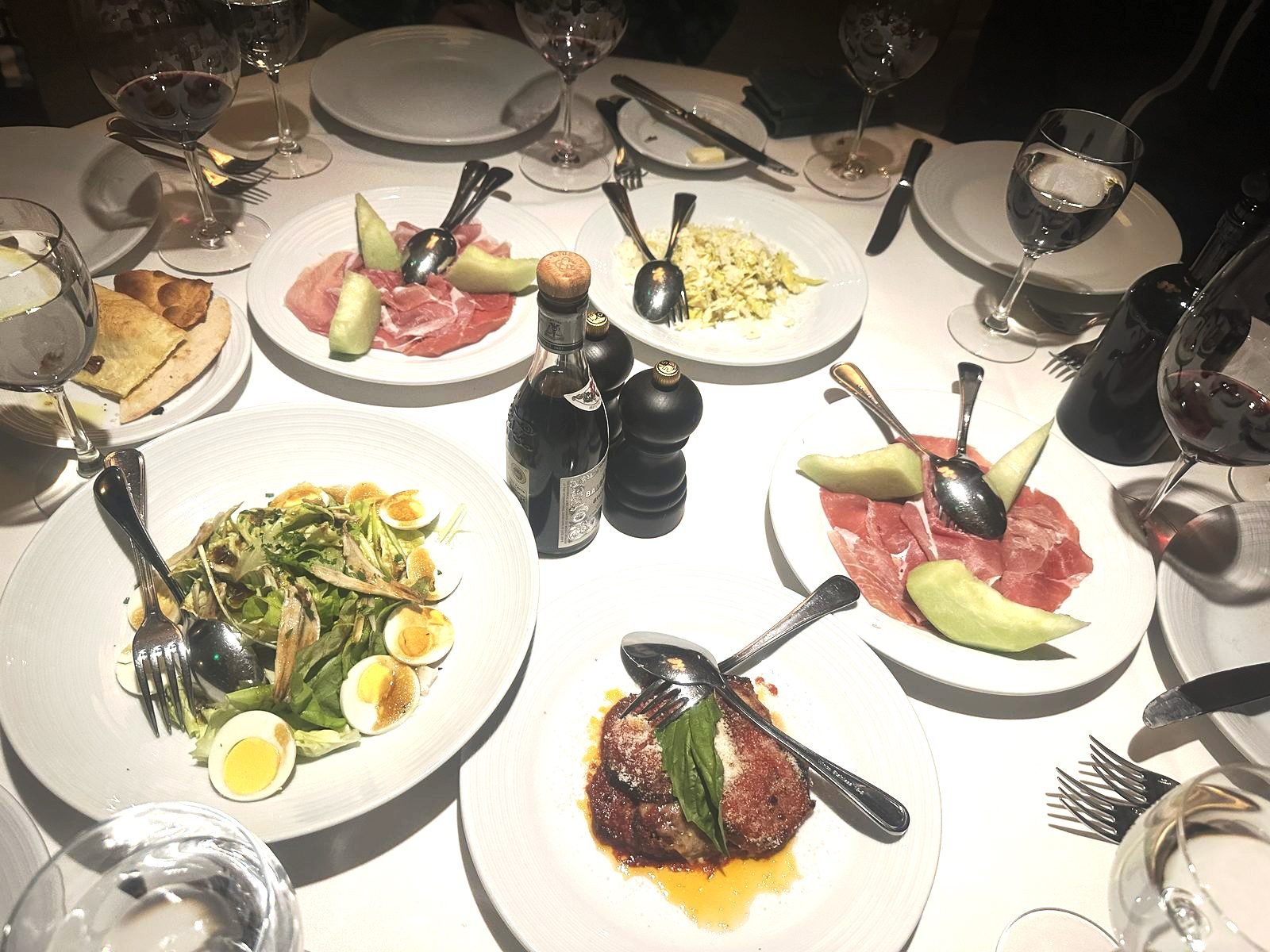 West Hollywood Madeo Ristorante table set with antipasti, salad and wine on a white tablecloth