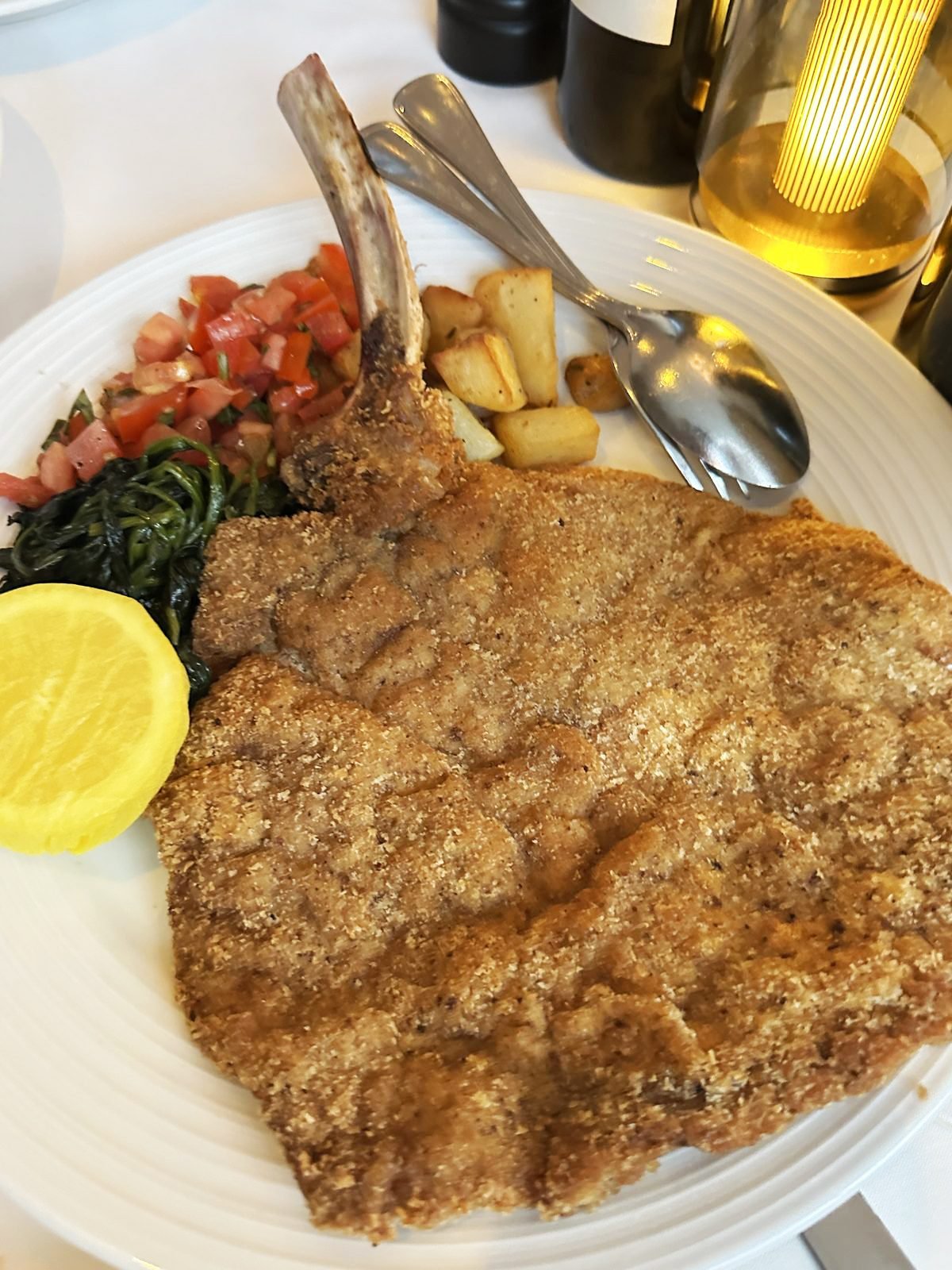 West Hollywood Madeo Ristorante veal milanese pounded past the edge of the plate with lemon, spinach and potatoes