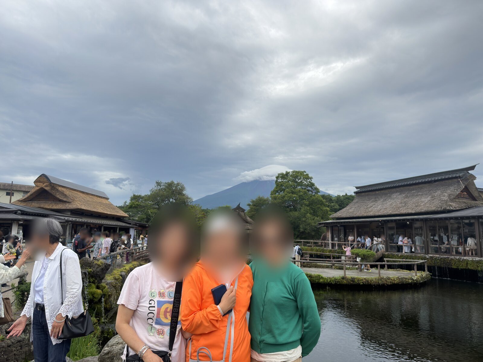 Thatched roofs and a clear pond at Oshino Hakkai with Mount Fuji behind